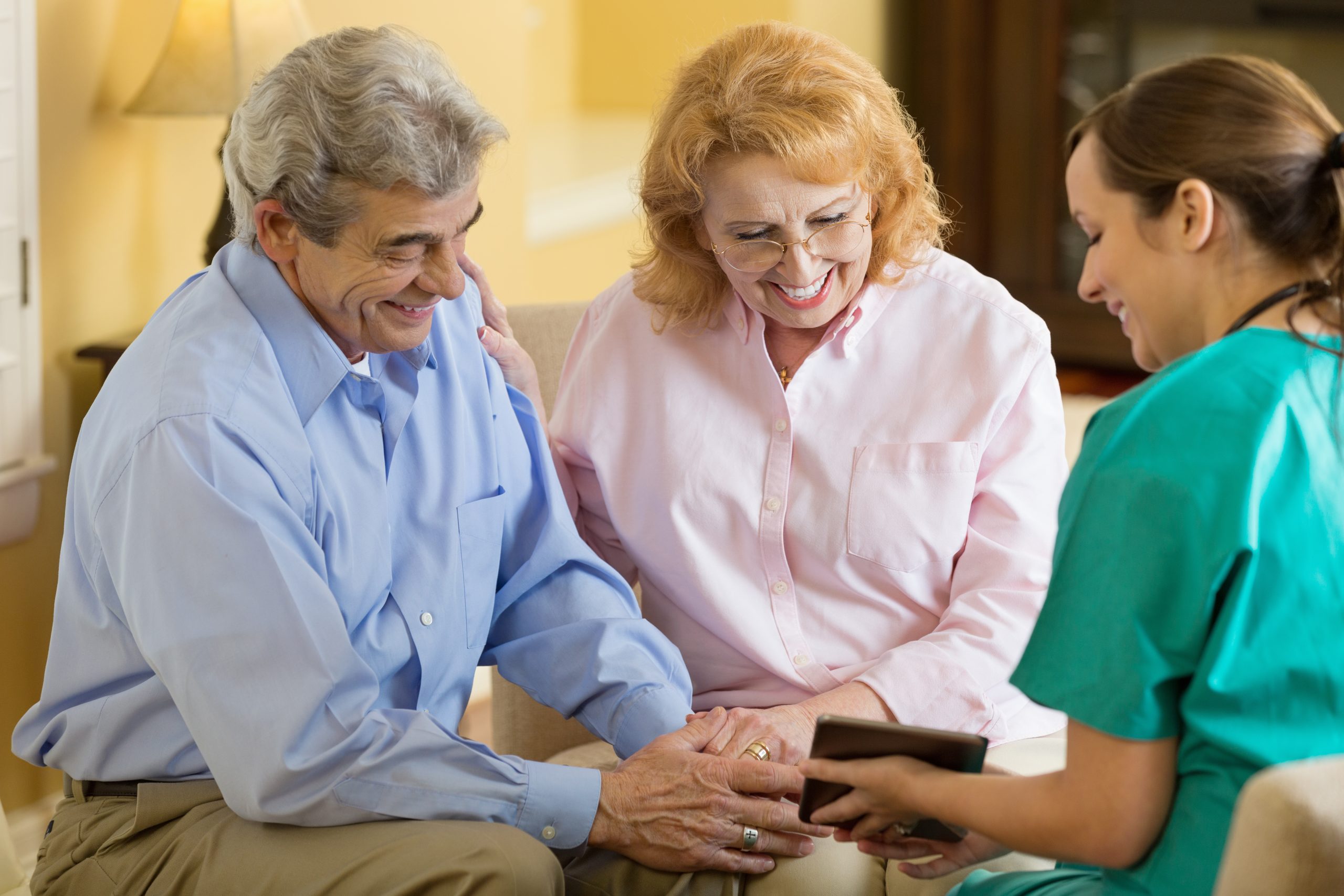 Home healthcare nurse using digital tablet during appointment with patient