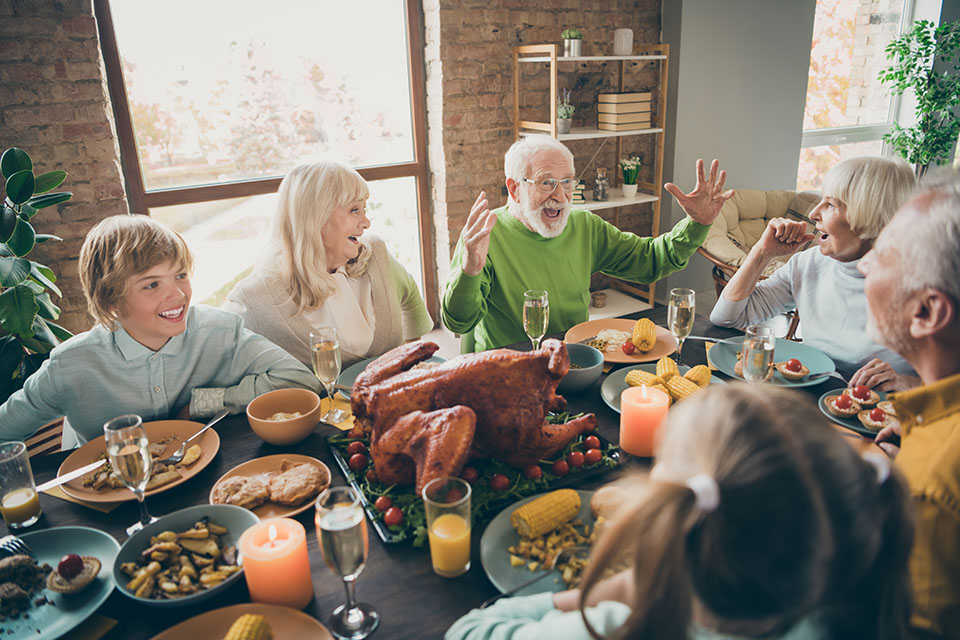 Photo of full family reunion gathering sit feast dishes chicken table communicating fall november autumn holiday multi-generation in evening living room indoors