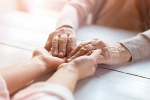 a senior holding hands with a younger family member